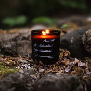 Candle labeled 'Amour' on a stone surface with a natural background